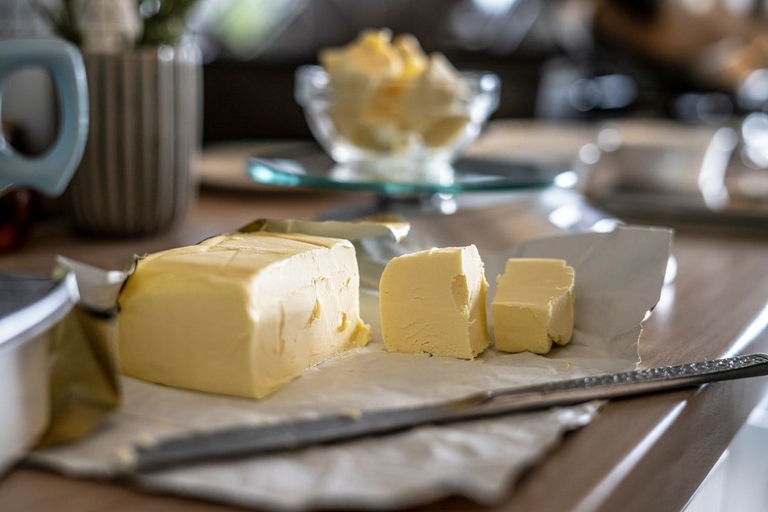 Kylskåpskallt smör i bitar på bakplåtspapper med kniv